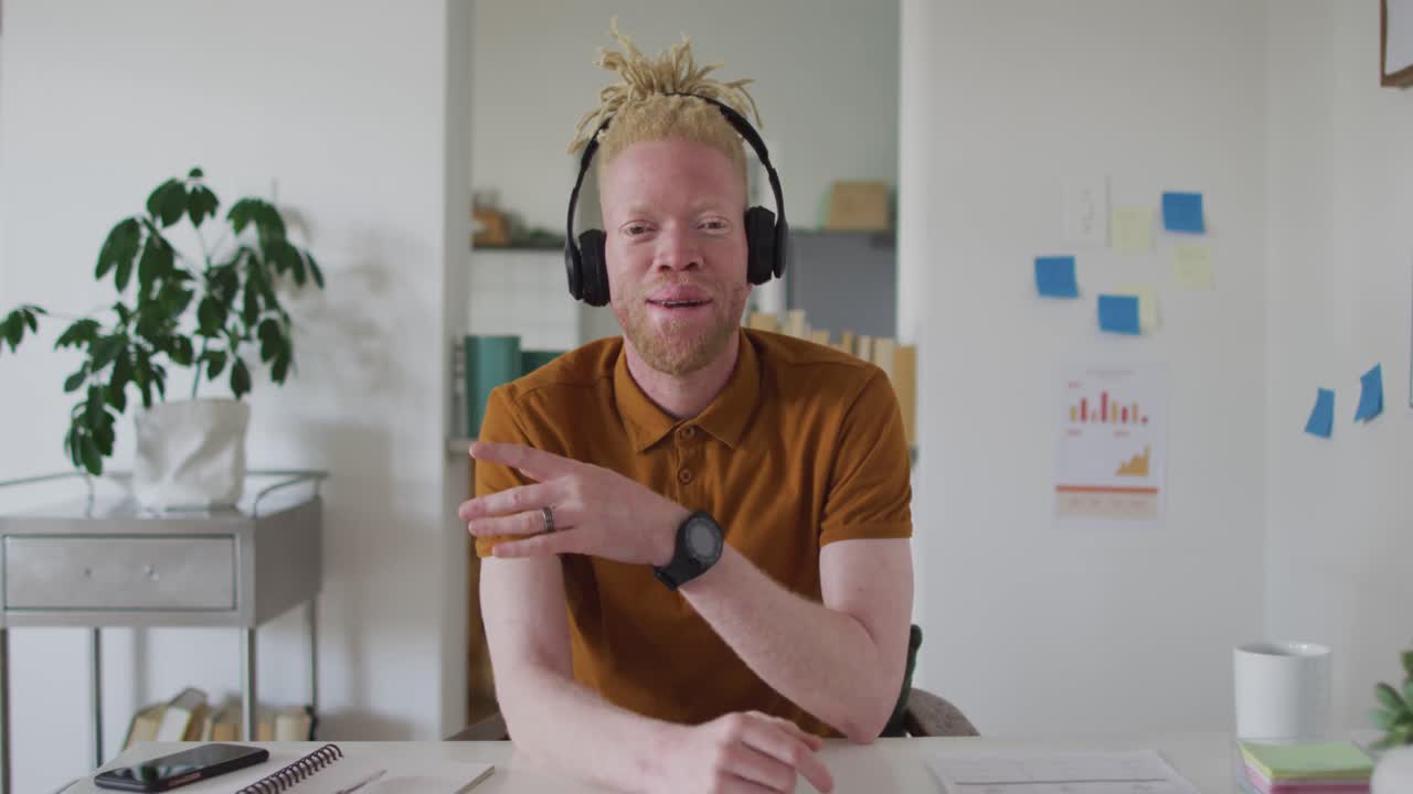 Albino african american man with dreadlocks making video call on the laptop