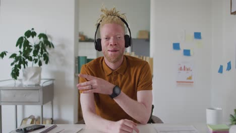 Albino african american man with dreadlocks making video call on the laptop