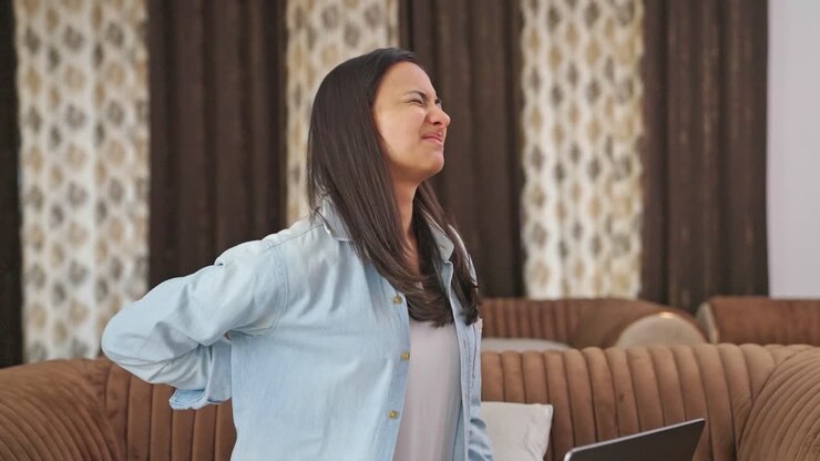 Indian woman suffering from back pain after working long hours