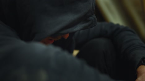 lonely person wearing hoodie, sitting head down depressed and sad