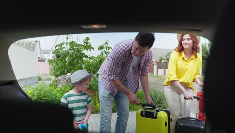 summer vacation, happy husband and wife with their beloved son load family travel bags in car for vacation trip