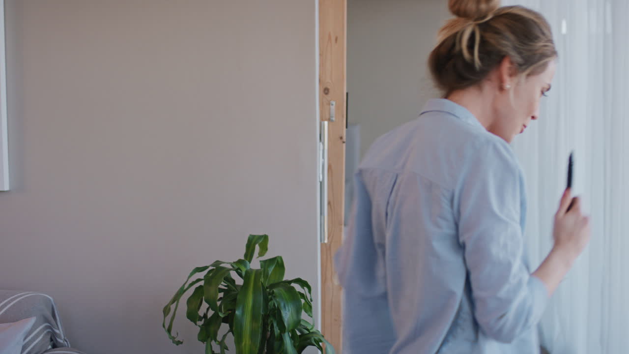 행복한 젊은 여성이 집에서 노래하고 즐겁게 성공적인 라이프 스타일을 축하하고 춤을 추고 카라오케 음악 엔터테인먼트를 즐기고 있습니다.