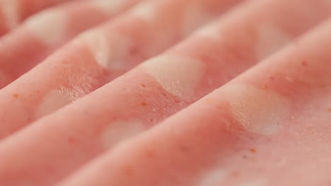 ham italian mordatella, man slices of traditional italian antipasti mortadella sausage on a wooden cutting board, close up macro of chicken or turkey jamon, fat breakfast dish.