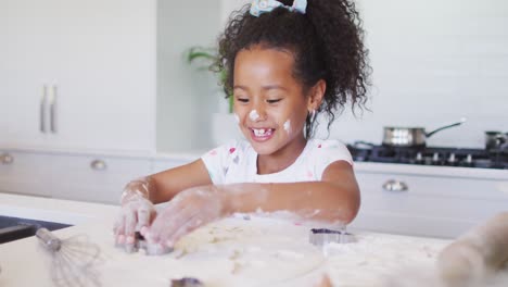 Happy-messy-african-american-girl-baking-in-kitchen