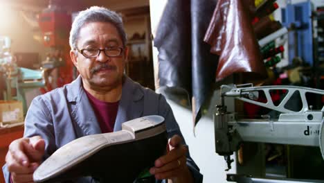 shoemaker examining a shoe