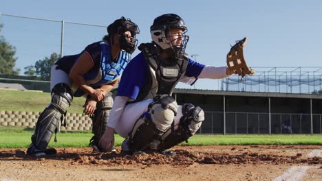 Diverse-group-of-female-baseball-players-in-action,-pitched-ball-caught-by-catcher-and-returned