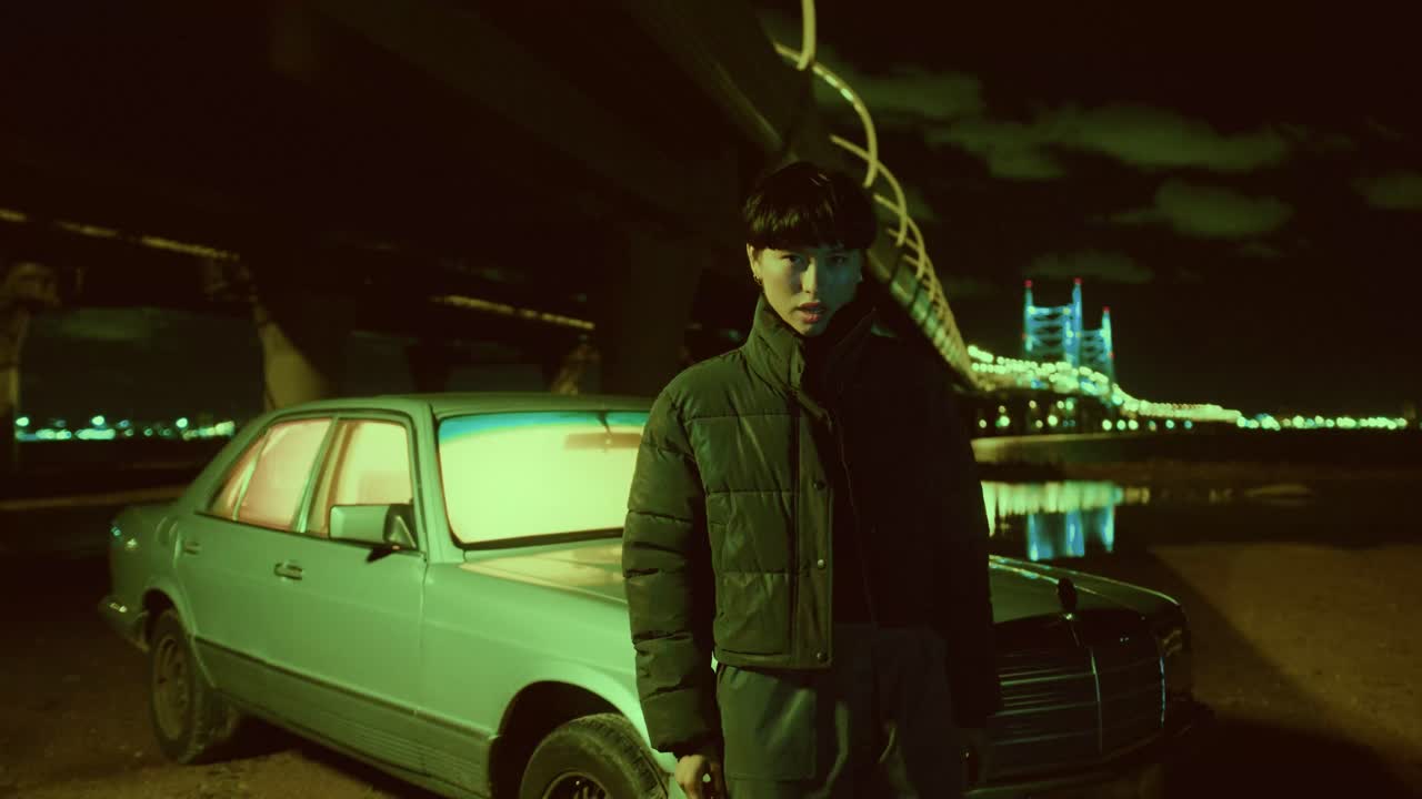 Woman posing with car at night