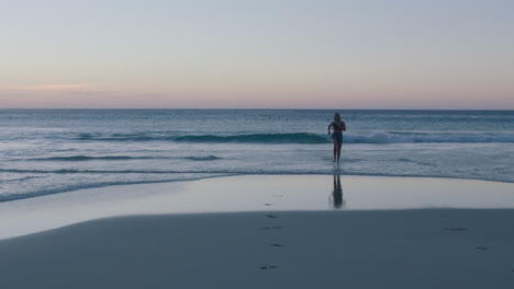 Mujer-Joven-Feliz-Corriendo-En-La-Playa-Sonriendo-Alegre-Disfrutando-De-Un-Estilo-De-Vida-Relajado-Y-Despreocupado-En-Vacaciones-De-Verano-Al-Atardecer