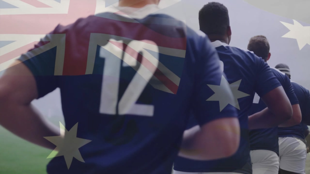 Rugby players jogging out of tunnel under translucent Australian flag forming lineup for kickoff