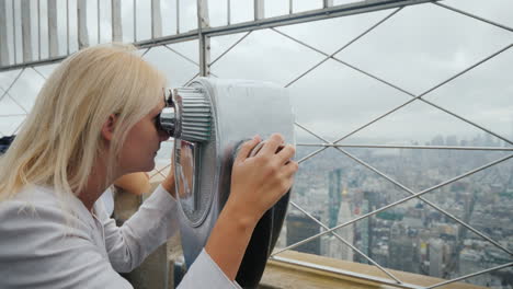 Blonde-Frau,-Die-Durch-Ein-Fernglas-Auf-Das-Panorama-Von-New-York-Schaut,-Besuchen-New-York-Concept