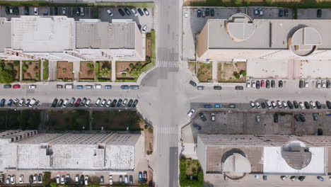 Top-down-aerial-footage-ascending-away-from-the-ground-showing-the-intersection-between-a-group-of-apartment-buildings-outside-of-Bari,-Italy