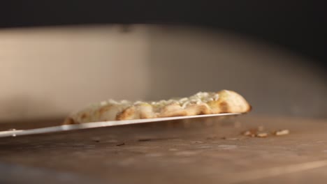 close-up of unrecognizable person turning pizza cooking in restaurant oven. professional chef cook preparing tasty bakery in kitchen. culinary and food concept