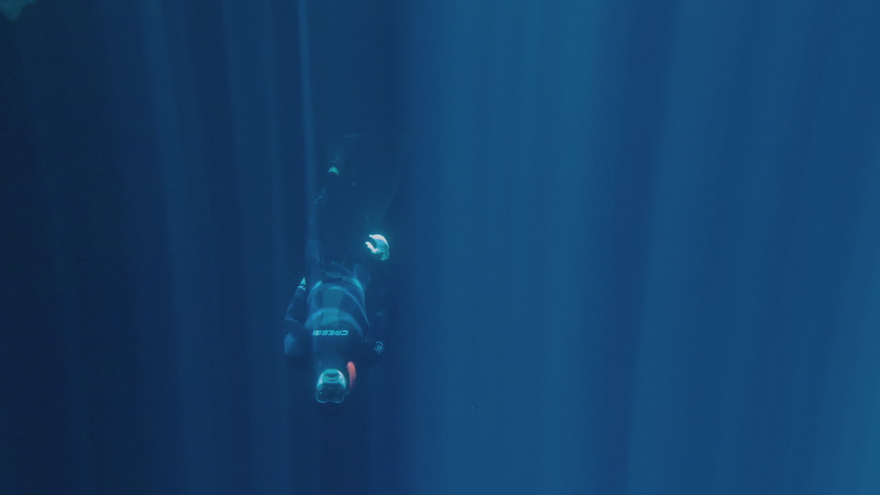 Underwater shot from Free diving into cave, clear water and gorgeous sun-rays entering from top. Slow motion 120fps