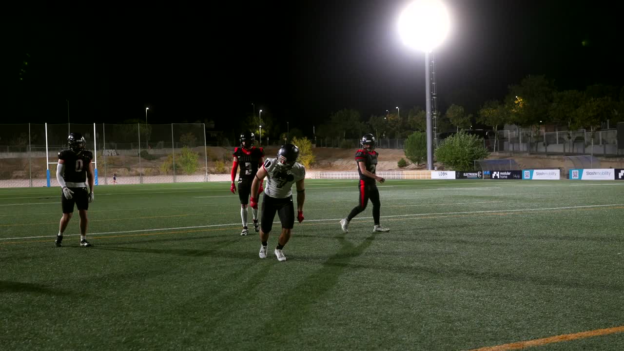 Football players practicing at night