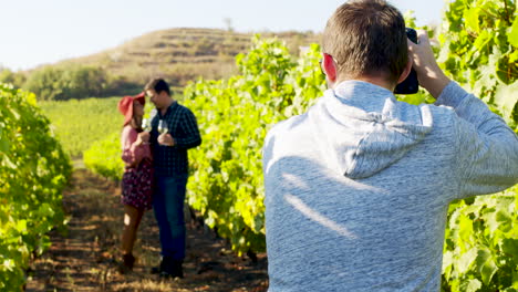 fotógrafo tomando fotos de una pareja encantadora en un viñedo