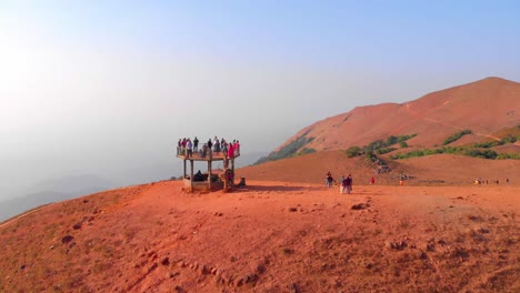 Drone-footage-moving-forwards-past-a-observation-tower-on-a-hill-to-reveal-rolling-mountains