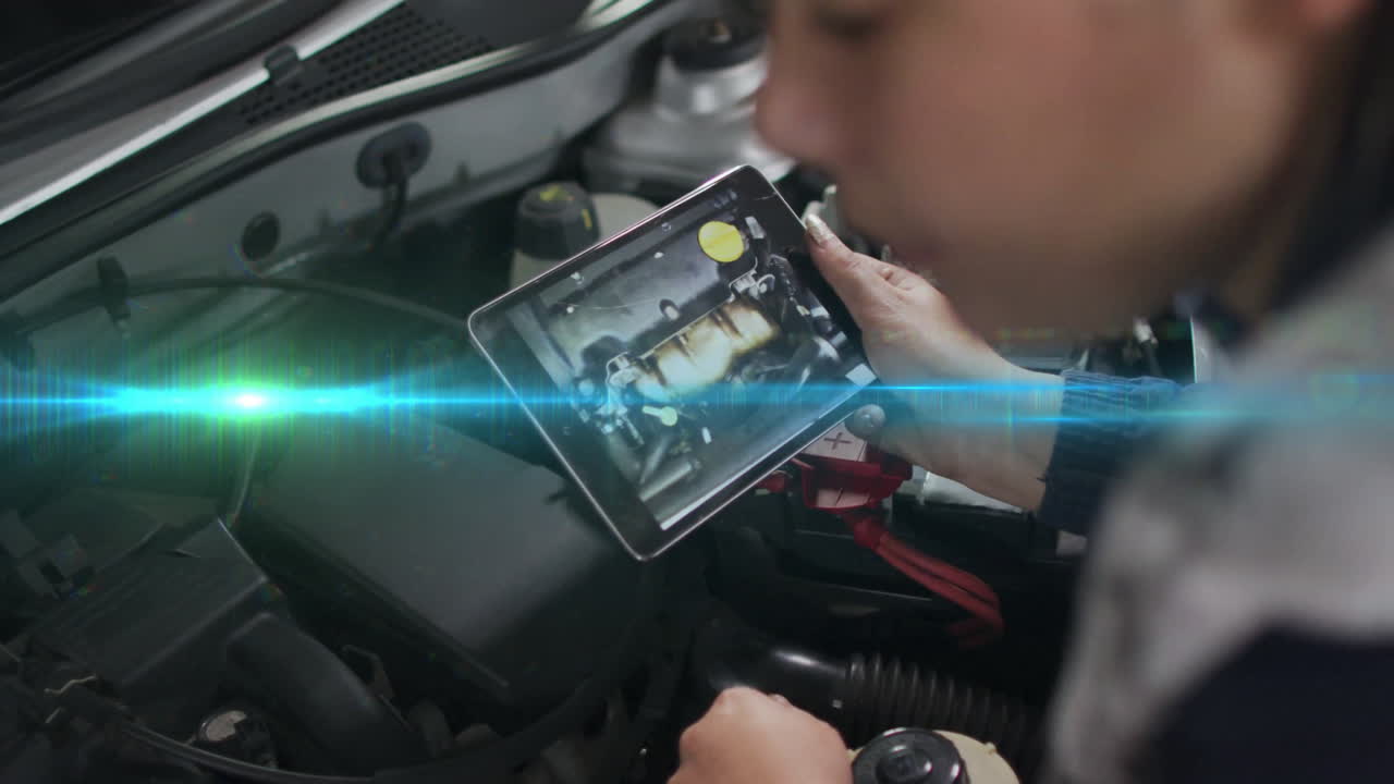 Automotive technician holding tablet under open hood, analyzing engine parts with animated overlay