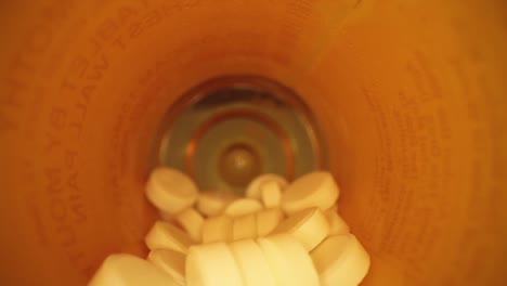 slowly pulling out the length of a prescription pill bottle, shallow focus to reveal textures