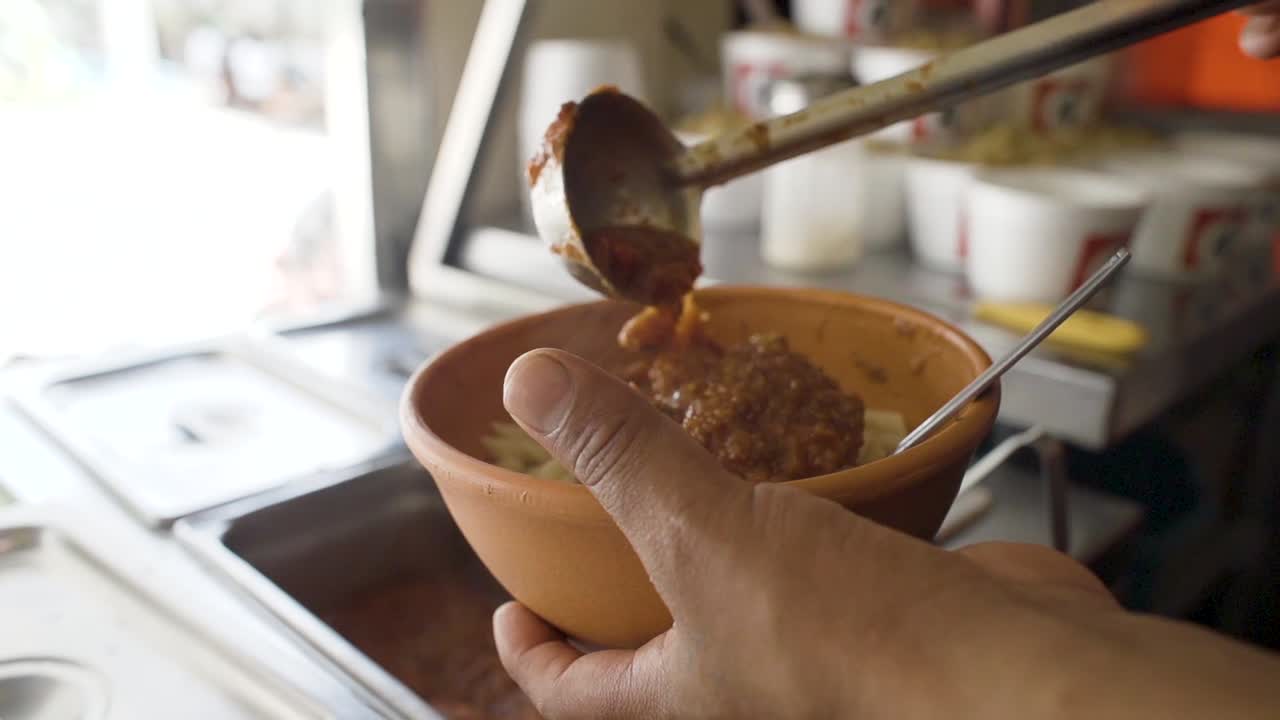 Serving  delicious salsa meat in the noodles slowly