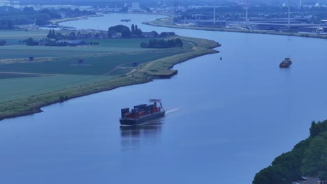 Luftaufnahme-Des-Frachtcontainerschiffs-Casa-Blanca,-Das-Während-Der-Blauen-Stunde-Entlang-Der-Nieuwe-Merwede-Fährt