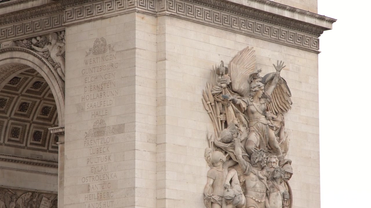 Lenta panoramica di intricate sculture in pietra e dettagli architettonici sull'Arco di Trionfo