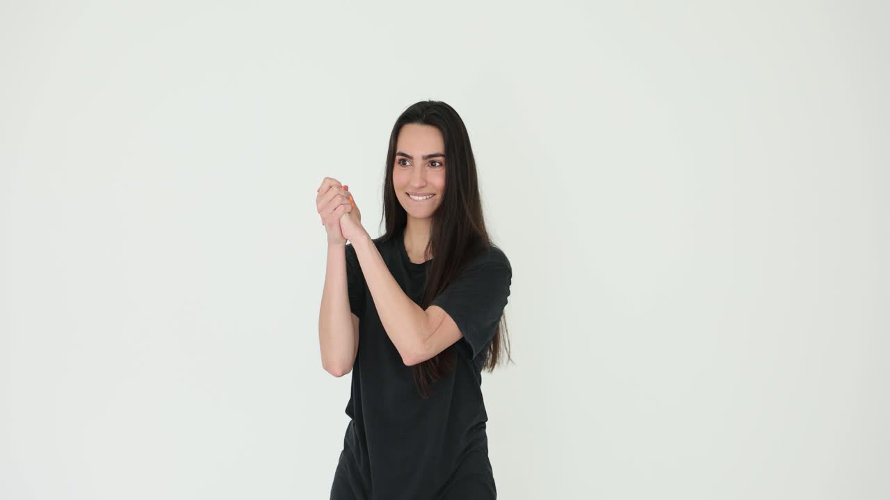 Woman in black t-shirt smiling and holding hands together