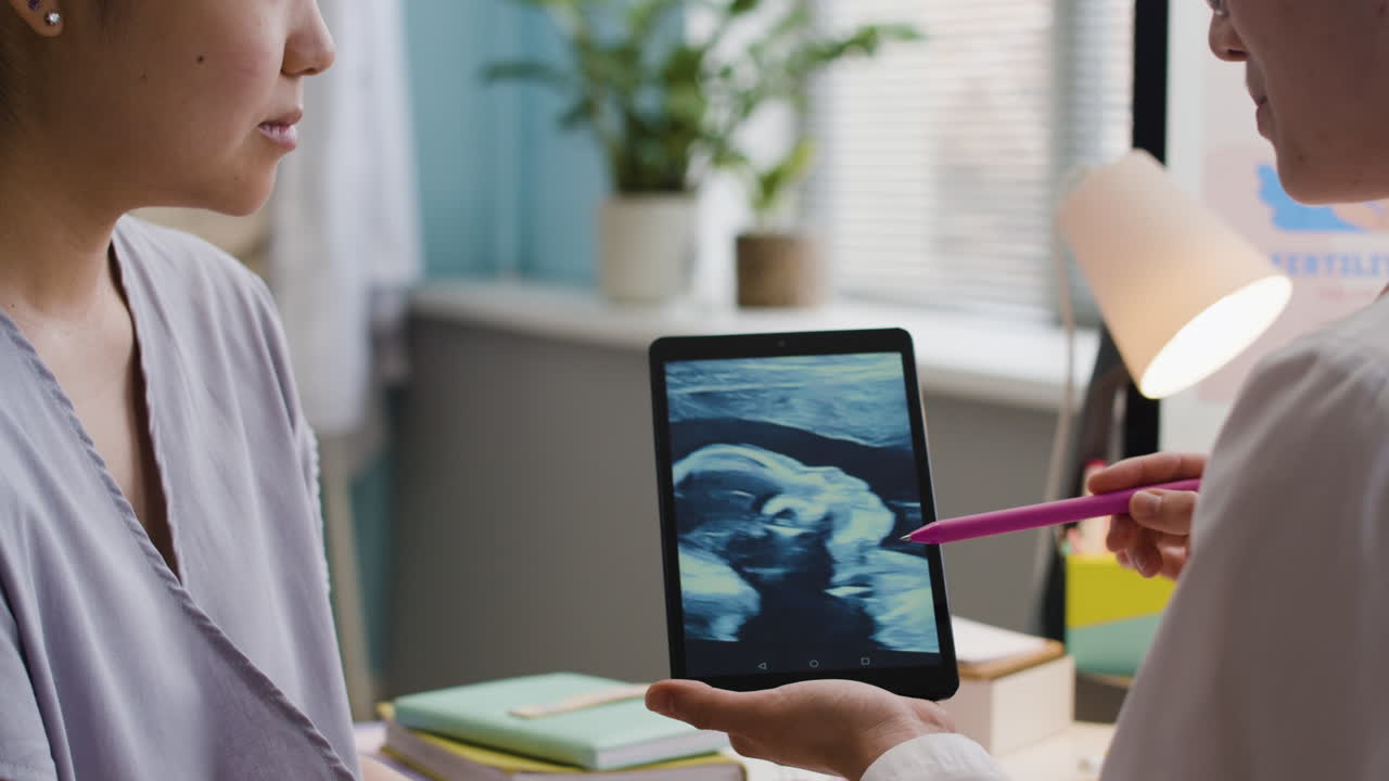 Doctor showing ultrasound to pregnant patient