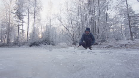 Un-Bañista-De-Hielo-Bien-Vestido-Termina-De-Cortar-Y-Levanta-La-Escotilla-De-Hielo