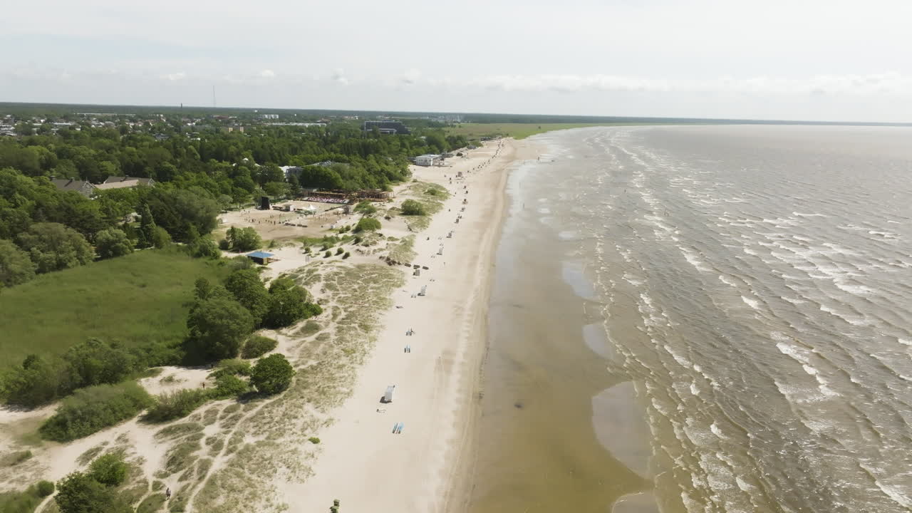 Aerial tracking shot of the Parnu rand beach, sunny, summer day in Estonia