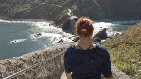 woman walking on the bridge to gaztelugatxe