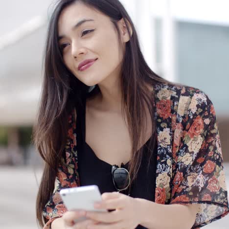 Mujer-Joven-Sentada-Leyendo-Un-Mensaje-De-Texto