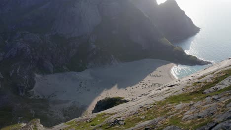 Dramatic-shot-over-Lofoten-steep-cliffs-and-mountains-to-the-sand-beach-bellow