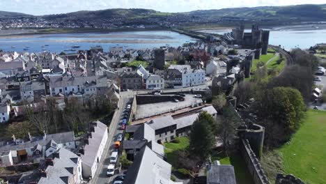 Welsh-holiday-cottages-enclosed-in-Conwy-castle-stone-battlements-walls-aerial-view-rising-above-bay