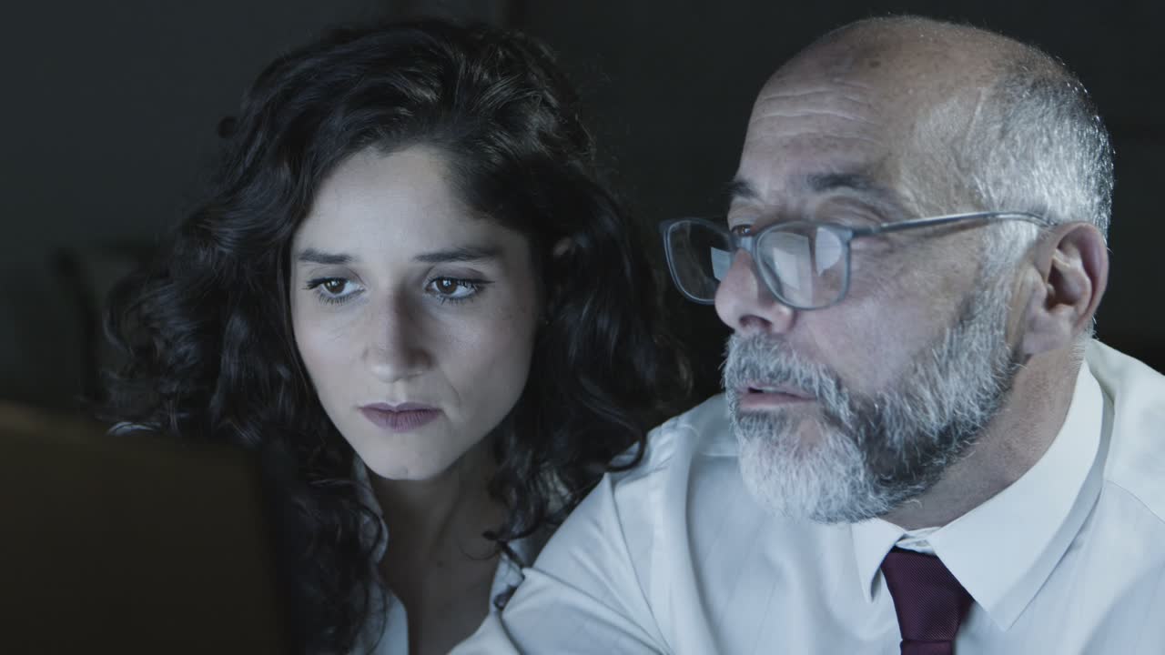 compañeros de trabajo enfocados en la oficina oscura