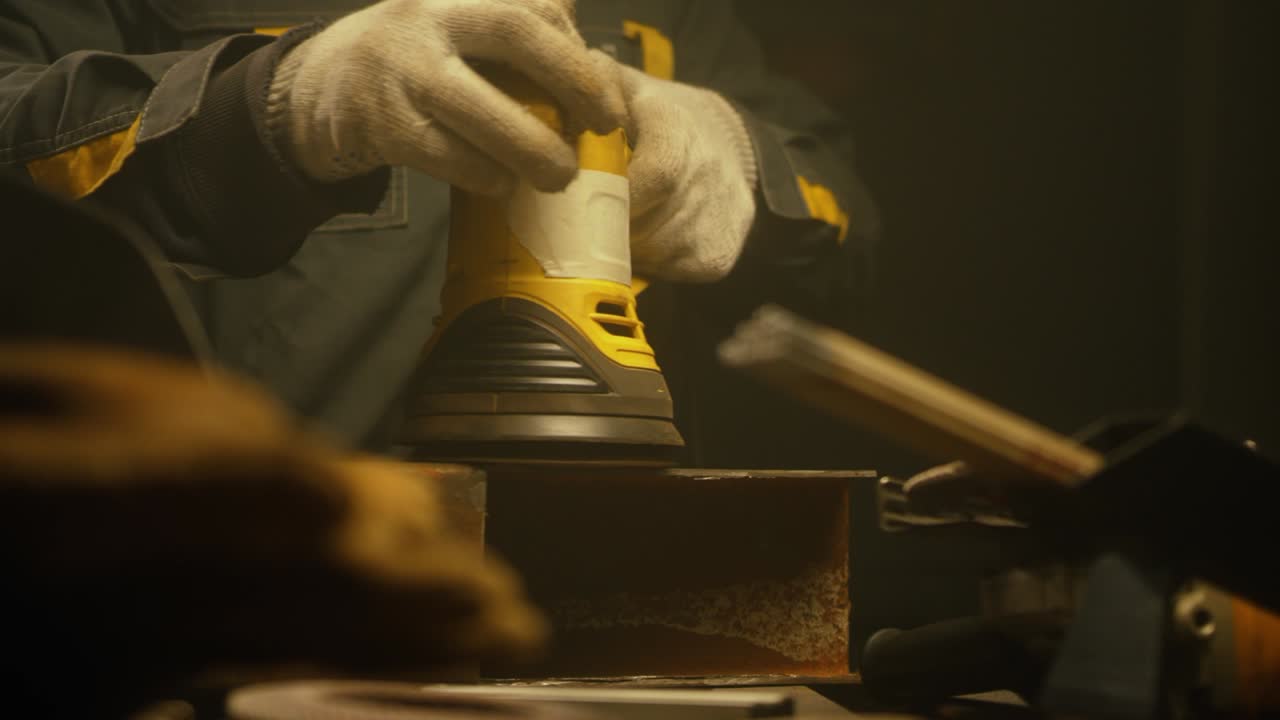 trabajador pulindo metal con un molinillo. interior de una fábrica de la industria pesada con un trabajador usando un molino. molienda eléctrica de tubos de acero en una fábrica. cámara lenta. up close. video 4k. filmado en rojo