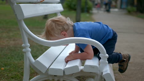 baby exploring a park bench