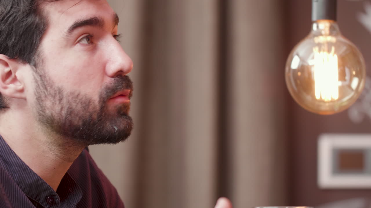 Man drinking beer with decorative lightbulb