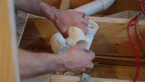 plumber applying glue to pvc pipe