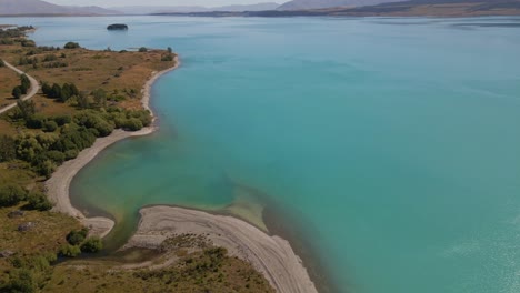 The-picturesque-shoreline-of-a-turquoise-glacial-lake-viewed-by-drone