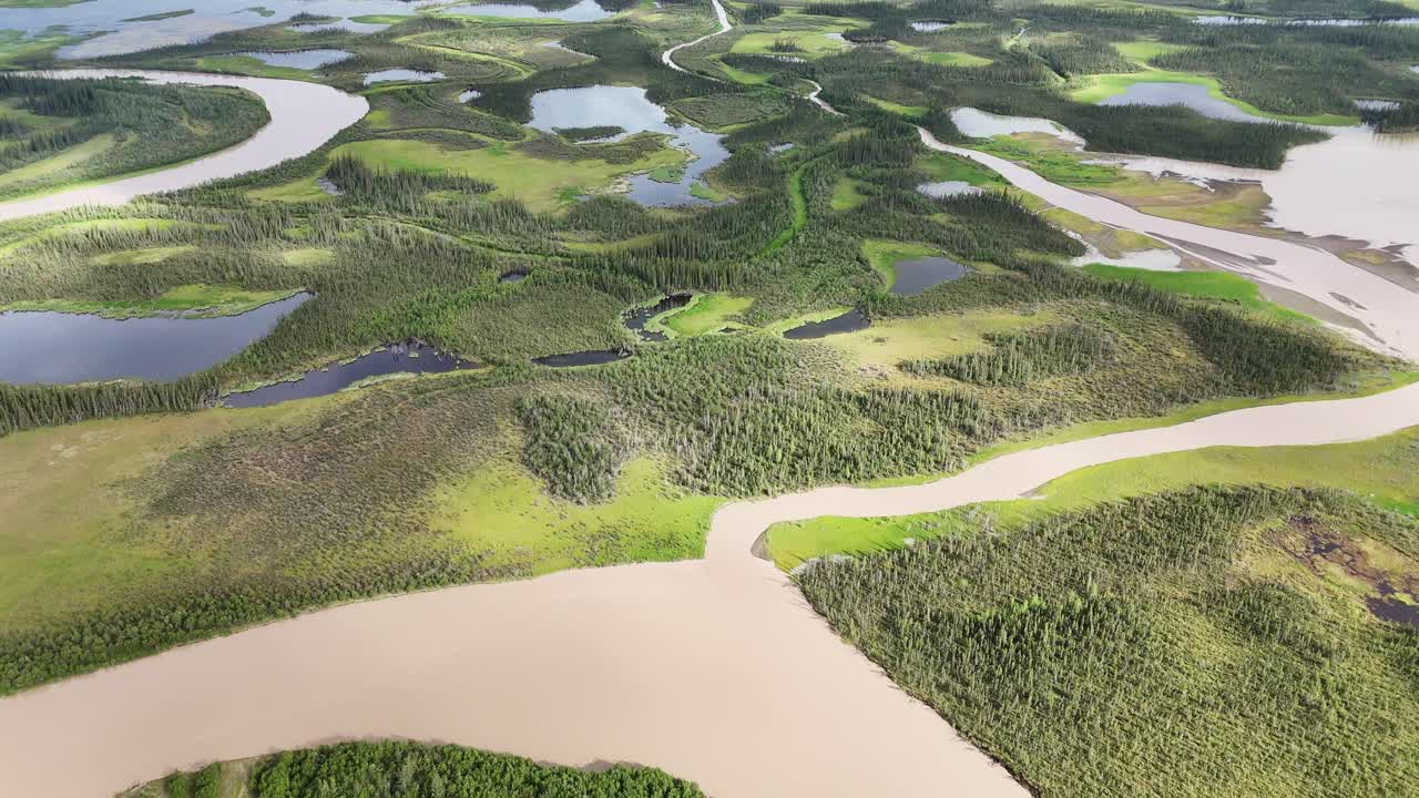 Aerial view of stunning river winding through lush green landscape in Alaska, perfect for nature documentaries and outdoor adventure promotions, showcasing pristine wilderness