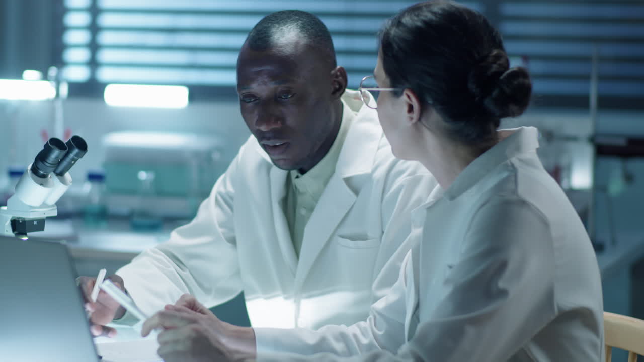 Two Lab Scientists Discussing Something on Laptop