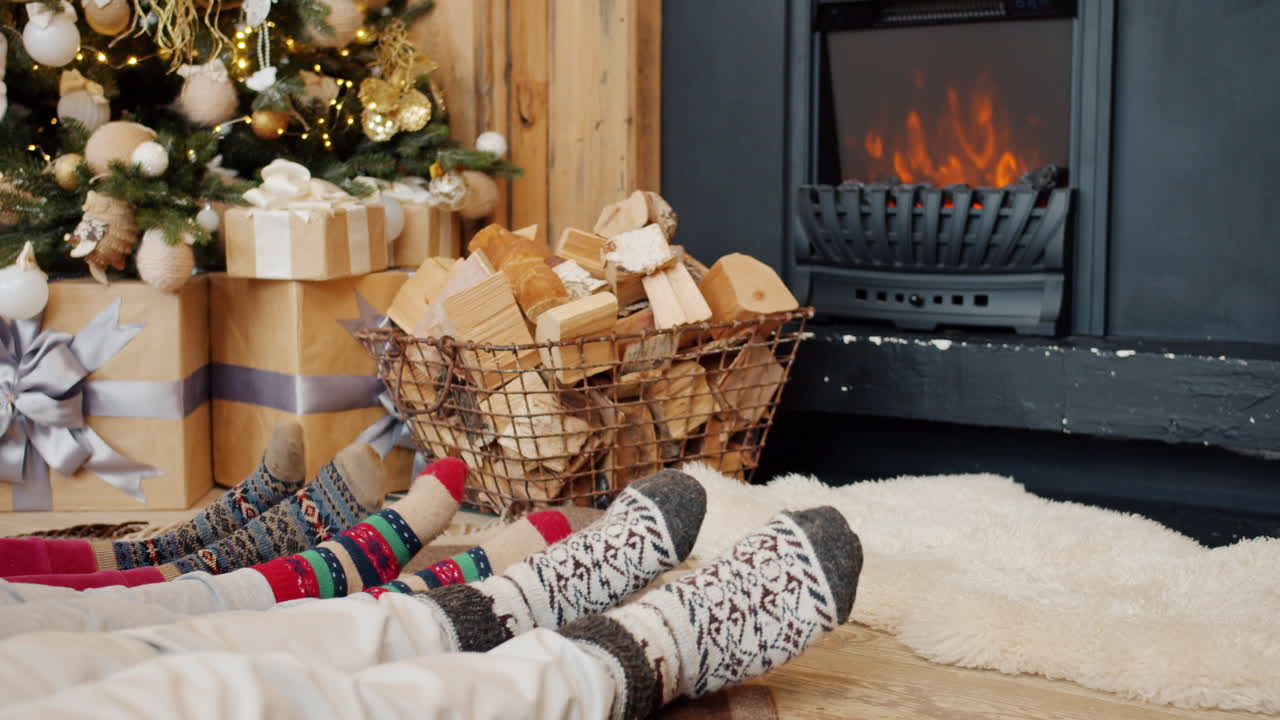 Family relaxing by the fireplace during Christmas