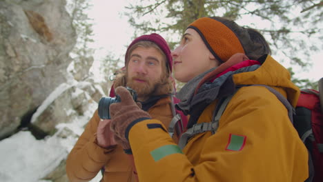 couple photographing mountains during winter hike