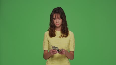 financial problems. frustrated young girl count cash need money for pay debt credit loan on chromakey green background
