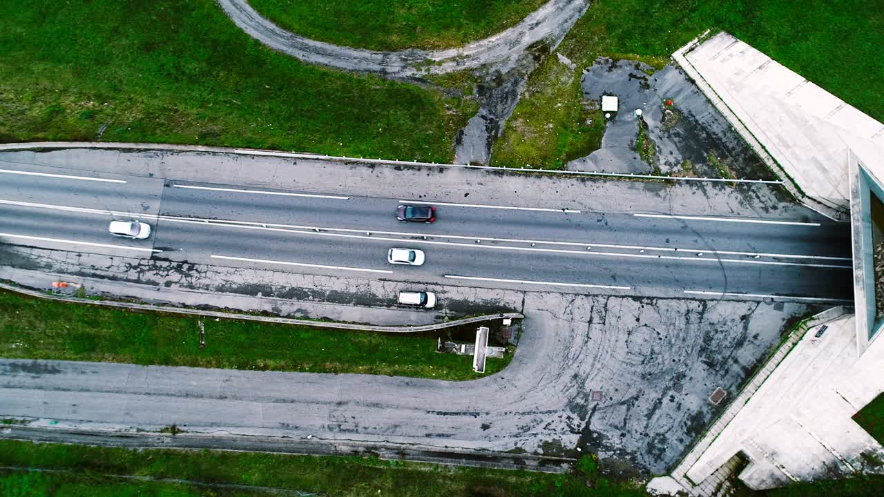 프랑스에서 터널로 들어가는 고속도로 도로 위의 아름다운 공중 풍경. 도로 주변에는 잔디과 나무만 있습니다. 도로에서 운전하는 자동차와 트럭.