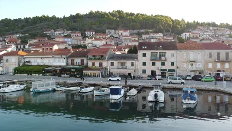 Drine-flying-sideways-with-cars-moving-along-the-harbour-walls-with-boats-in-Europe-at-sunrise