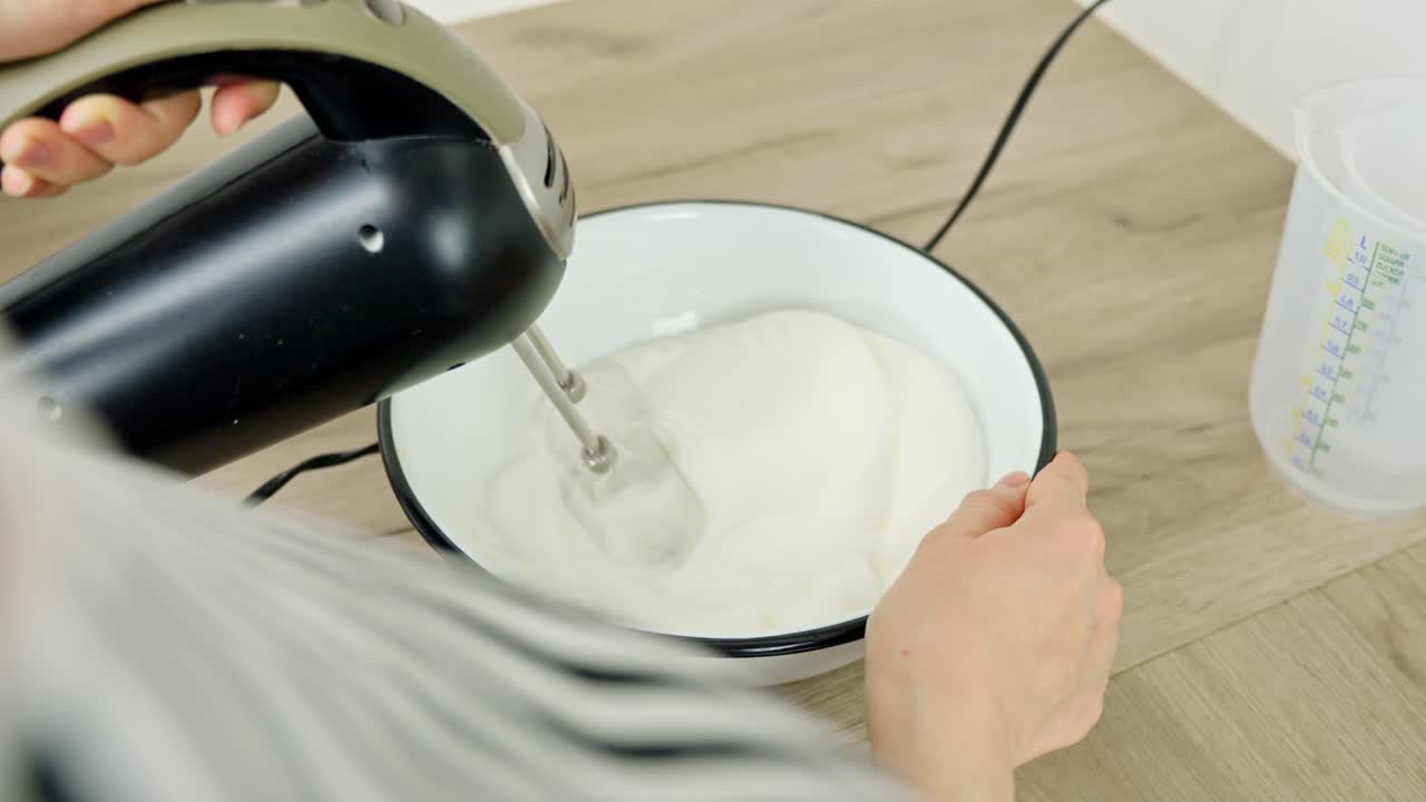 Whipping egg whites with an electric mixer for a homemade tiramisu dessert