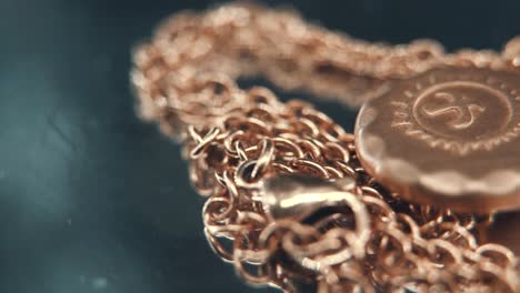 a macro shot of a golden medallion necklace, flying bird in the middle of the sun symbol, on a rotating stand, mirror reflection, studio lighting, 4k video