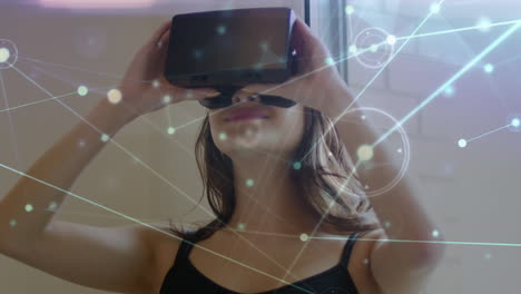 animation of network of connections over caucasian woman using vr headset