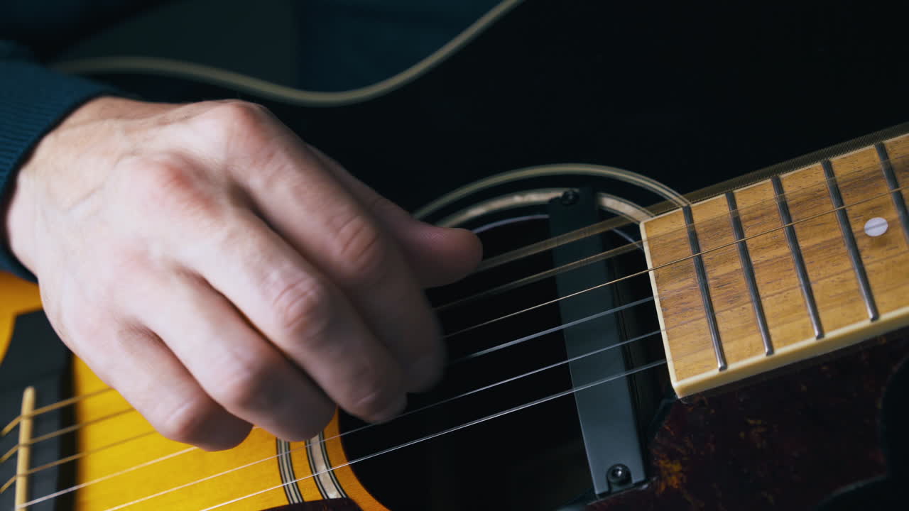 el guitarrista profesional se calienta tocando melodías simples.